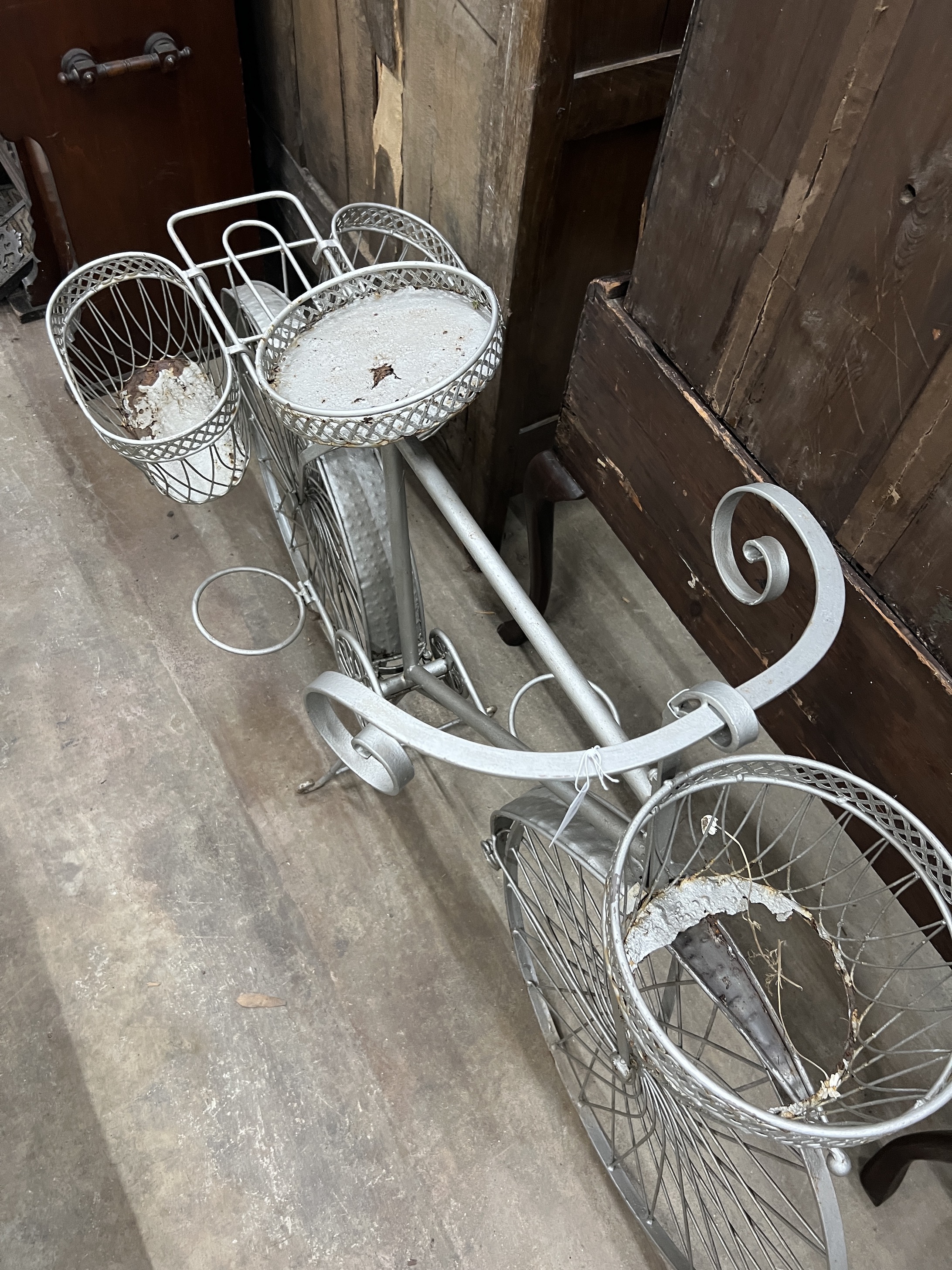 A wrought metal ' Bicycle' garden pot stand, length 144cm, height 90cm